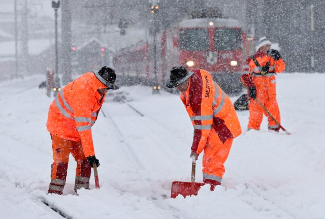 Radnici čiste šine na željezničkoj stanici u Disentis u Švajcarskoj. Јak snijeg u jugoistočnoj Švajcarskoj izazvao je probleme u železničkom saobraćaju.