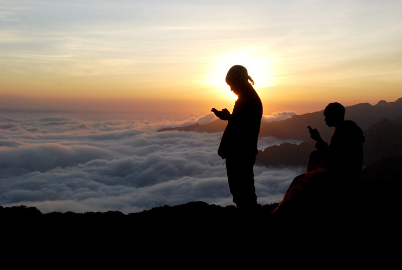 Tanzanijski reporteri i vodič na pola puta ka vrhu Kilimandžara pred zalazak sunca, pokušavaju da dobiju signal 
kako bi se javili svojim ženama...