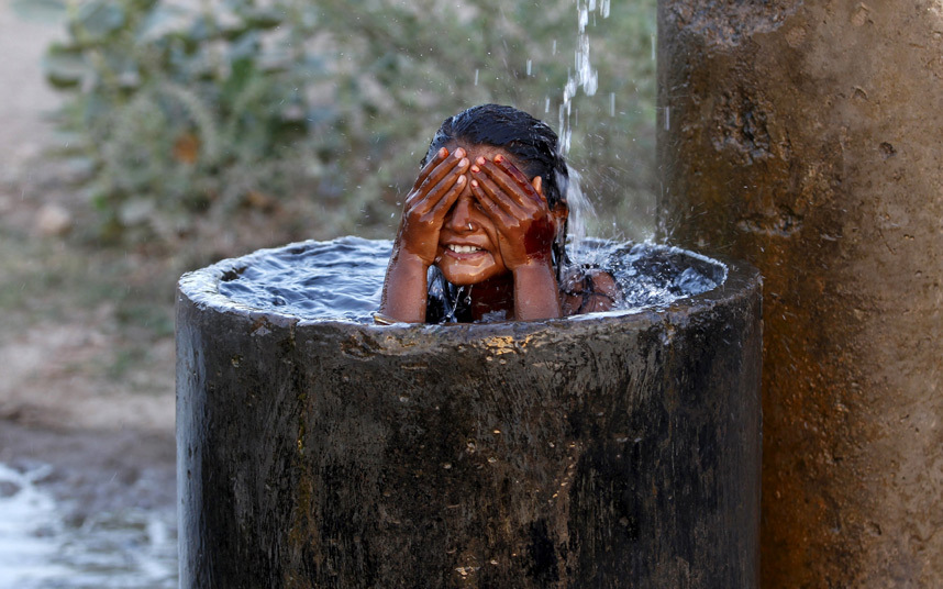 Djevojčica pokušava da se ohladi tokom toplih dana koji su pogodili Indiju gdje su temperature išle i iznad 45 stepeni...