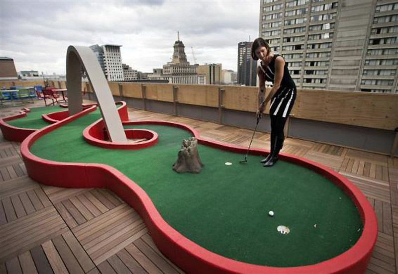 Guglov zaposlenik pokazuje kako se koristi mini-teren  za golf na balkonu nove Guglove kancelarije u Torontu...