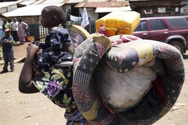 Žena nosi svoje dijete u Minovi, oko 45 km (28 milja) zapadno od Gome, Demokratska Republika Kongo.