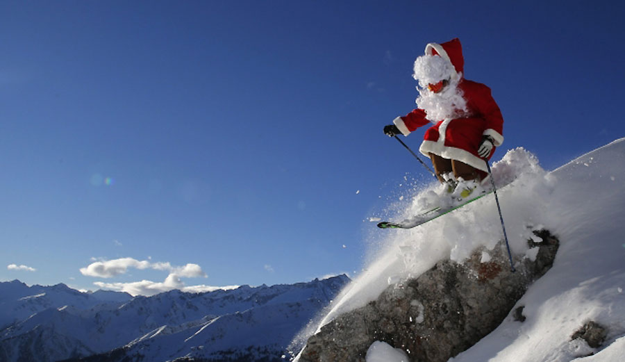 U kostimu Djeda Mraza, učitelj skijanja Alberto Ronči izvodi skijaške skokove u mjestu Madona di Kampiljo u sjevernoj Italiji...