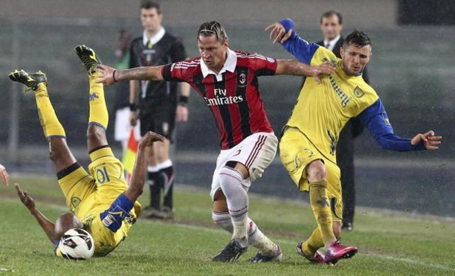 Fudbaler Milana, Filipe Mekses u borbi za loptu prodiv dvojice igrača Verone na fudbalkom meču 30. marta 2013. godine