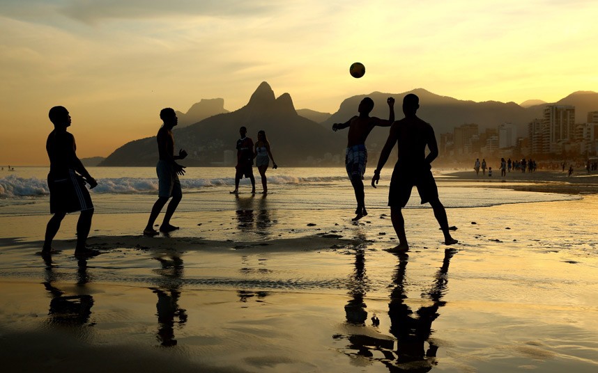 Mladići igraju fudbal tokom zalaska sunca na Ipanema plaži u Riju, Brazil...