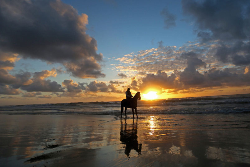 Čovjek iz Palestine  jaše konja u zalazak Јabaliia plaži u pojasu Gaze