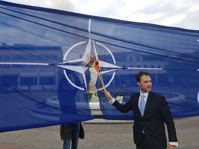 Marko Milačić pali zastavu NATO-a (Foto: Sputnik / Nebojša Popović) - 